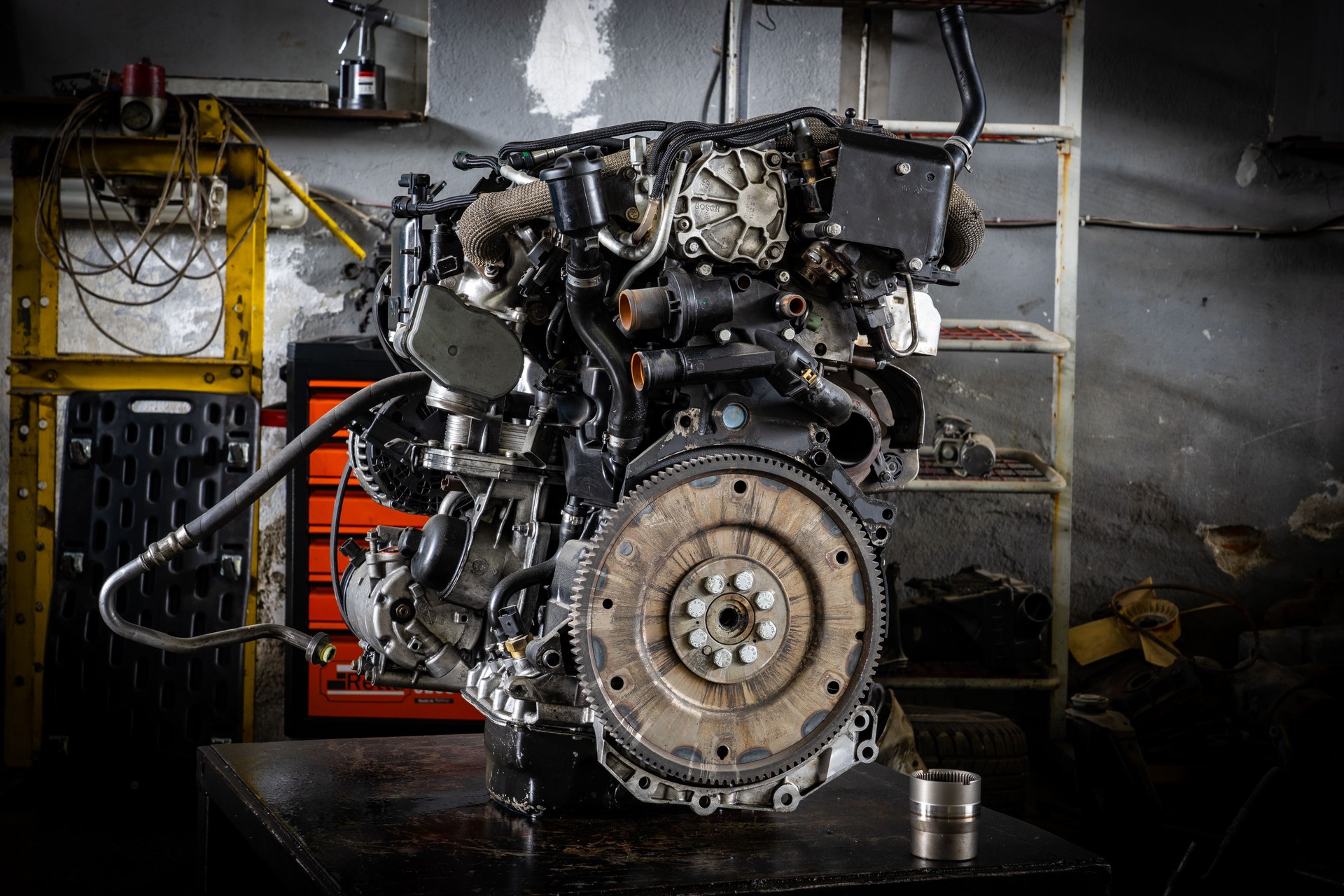 Used car engine placed on workbench in mechanical workshop